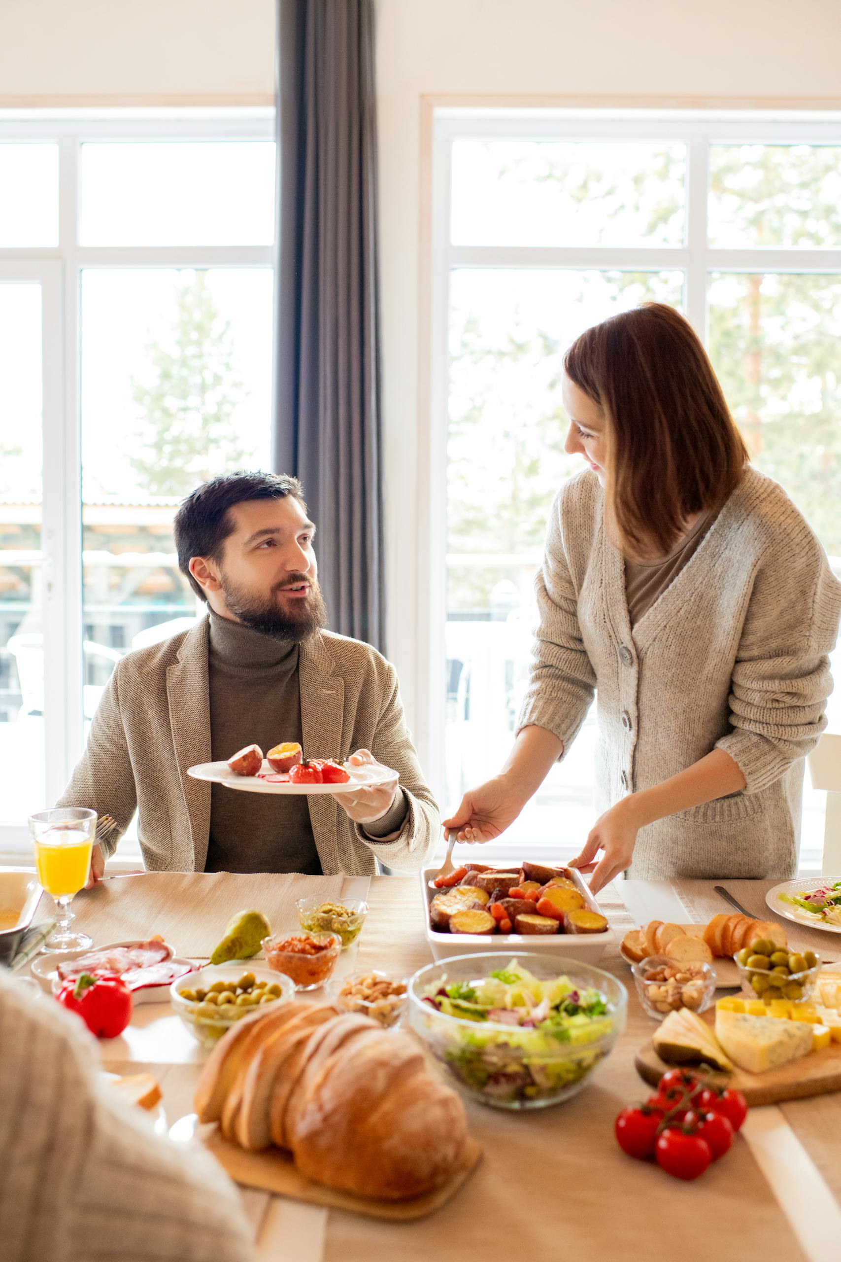 A friendly brunch gathering indoors with a variety of delicious foods on the table.